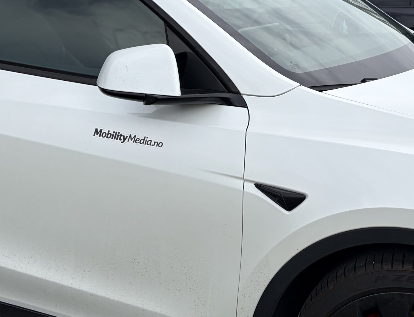 Nærbilde av MobilityMedia-logo på ambassadørbil i Moss